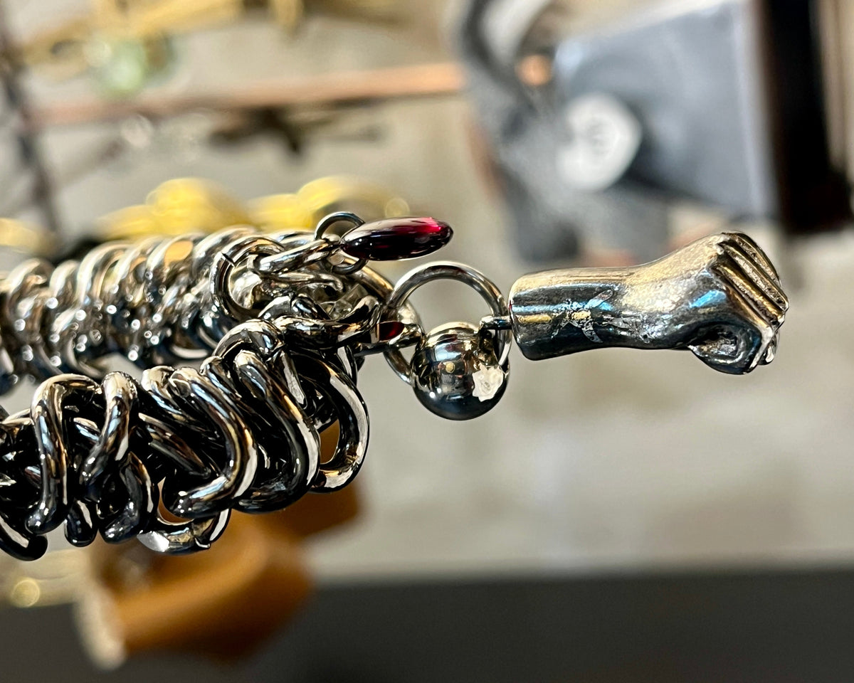 Close-up of a silver bracelet with a unique design and charm.
